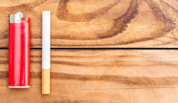 istock Lighter and cigarette on wooden background. Space for text. 1034438316
