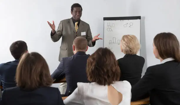 Smiling man giving presentation to colleagues at international business meeting