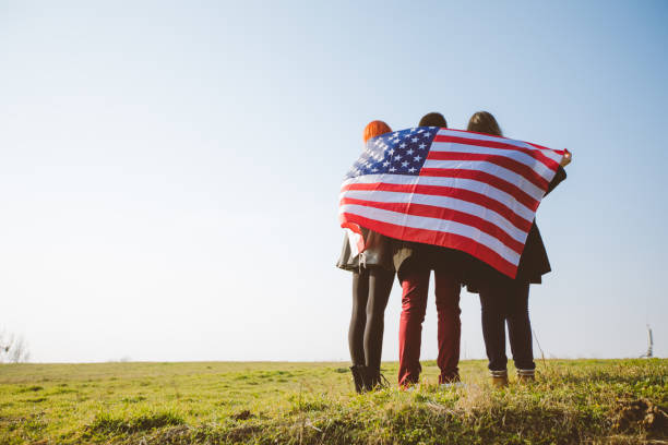 istock Three people wrapped in USA flag 1034457874