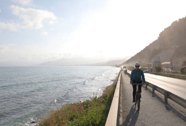 istock Woman cycles along Mediterranean coastline 1034458522
