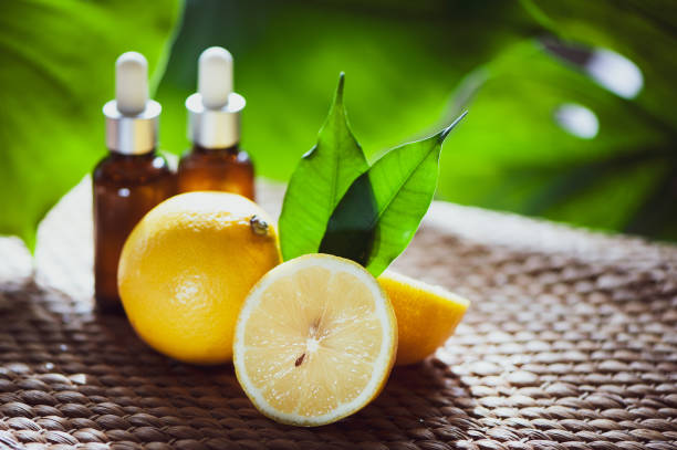 istock Bottles with lemon oil, fresh  fruit whole and half on a natural tropical background. 1034458764