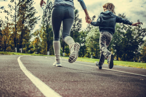 Boy tying shoelace on his sneakers on outdoor running track