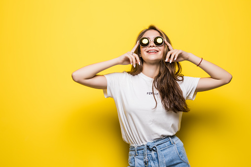 Portrait of beautiful woman in sunglasses against of yellow background.