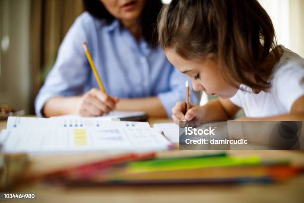 Mother Helping Daughter With Homework Stock Photo - Download Image Now - Child, Homework, Tutor