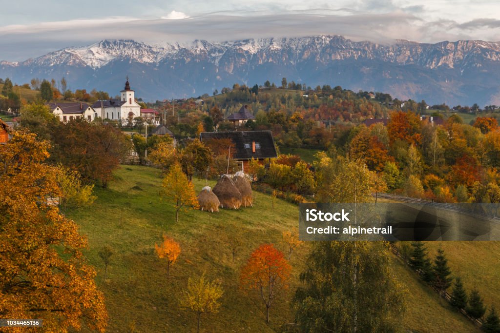 Autumn alpine landscape, alpine village with spectacular gardens and high snowy mountains in background near Bran, Magura, Transylvania, Romania. Autumn alpine landscape, famous alpine village with spectacular gardens and high snowy mountains in background near Bran, Magura, Transylvania, Romania. Church Stock Photo