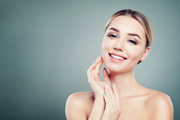 istock Healthy face young smiling woman on blue background with copy space 1034468820