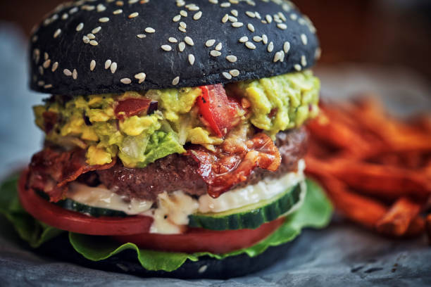 istock Black Burger Buns with Beef Pattie, Guacamole, Tomato and Lettuce 1034483684