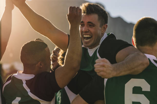 Rugby team cheering and celebrating victory Rugby team cheering and celebrating victory. Rugby players cheering together on field after winning the competition. rugby team stock pictures, royalty-free photos & images