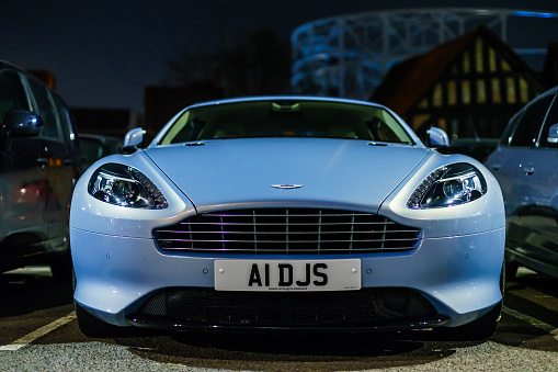 Coventry, UK - March 11, 2017 :  Image of Parked Aston Martin on the city carpark in night.