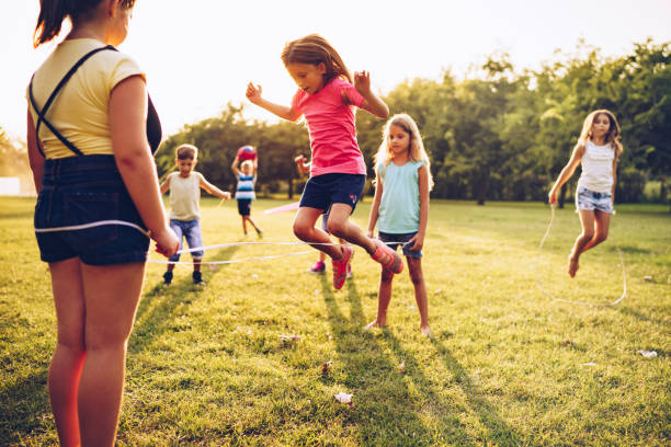 istock Group of kids playing outdoors jumping the ruber band 1034539578