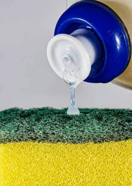 Photo of Kitchen detergent falling into the dish washer closeup photo