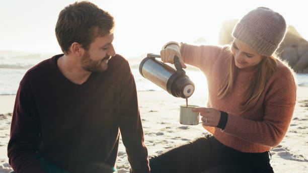 istock Beautiful young couple having coffee at the beach 1034555858