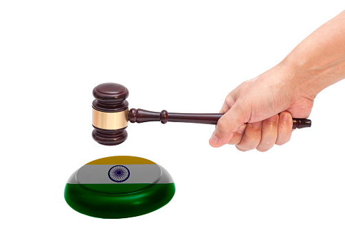 Hand knocking a Judge gavel at soundboard with Indian flag Isolated on white background