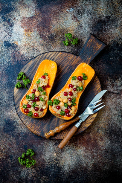 istock Stuffed butternut squash with chickpeas, cranberries, quinoa cooked in nutmeg, cloves, cinnamon. Thanksgiving dinner recipe. Vegan healthy seasonal fall or autumn food 1034584208