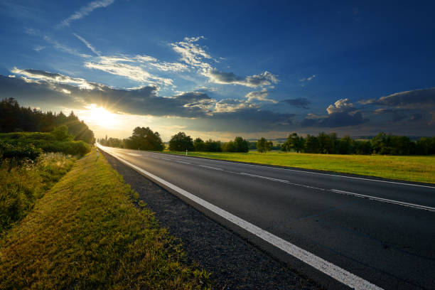 Empty asphalt road in the countryside at sunset Empty asphalt road in the countryside at sunset empty road stock pictures, royalty-free photos & images