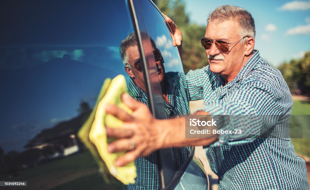 Senior man washing car Washing car. Senior man polishing his car with microfiber cloth Car Stock Photo