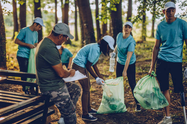 istock Volunteers with garbage bags in public park 1034595392