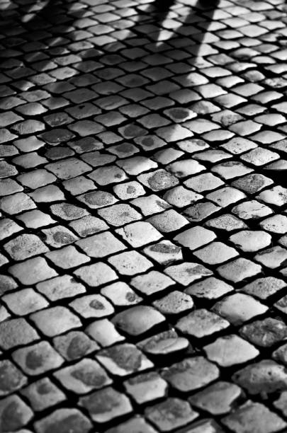 istock Faint shadow of a man on cobblestones 1034599878