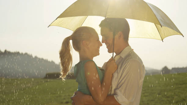 istock CLOSE UP: Smiling couple standing in each other's embrace during a spring shower 1034600496