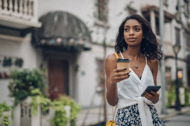 istock Woman with coffee cup and mobile phone 1034601126