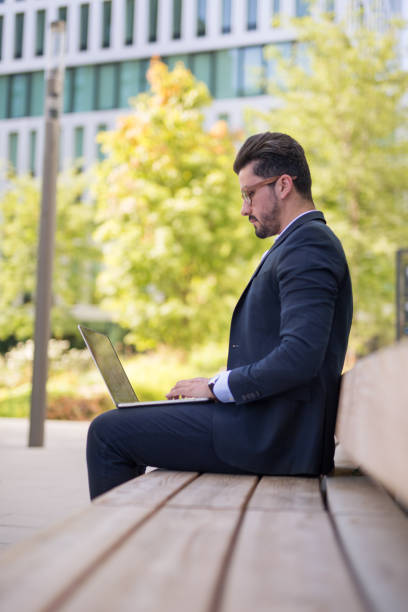 istock Handsome young businessman working outside on his laptop 1034603408