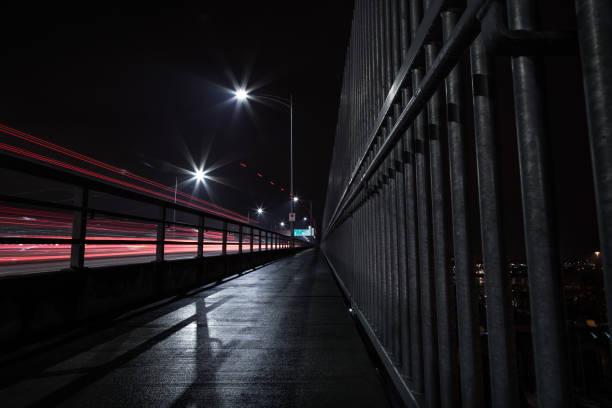 istock The Second Narrows Bridge sidewalk at night, with light trails from passing cars. 1034606388
