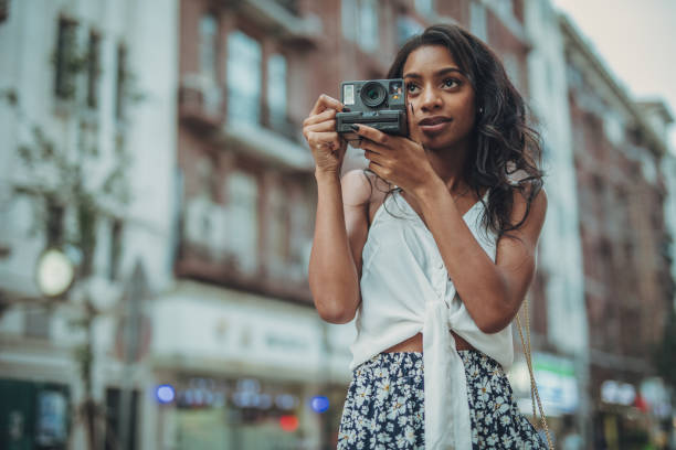 istock Young woman holding instant camera 1034606524