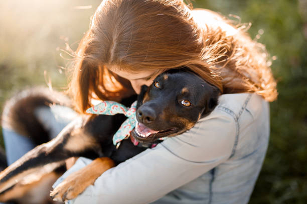 Girl hugging her cute black mutt dog