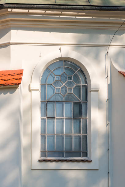 istock a window with an arch and a lattice, a white wall of a building 1034619978