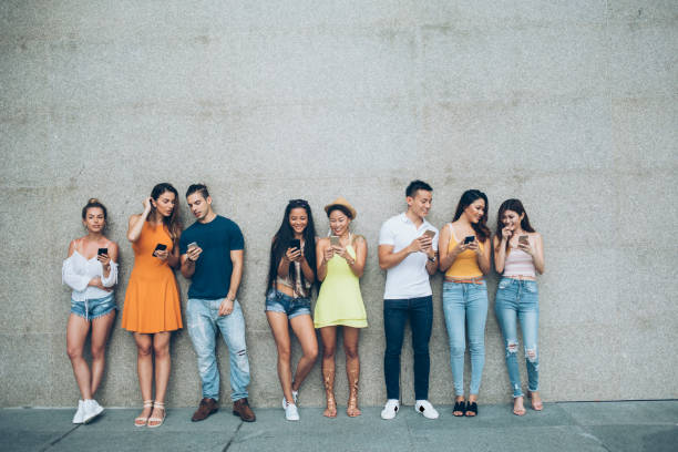 istock Young people leaning back on a wall and typing 1034620184
