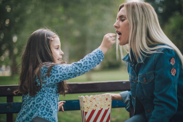 istock Mother and daughter eating popcorn 1034620766