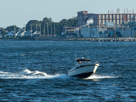New Bedford, Massachusetts, USA - September 5, 2018: Powerboat flying over choppy waves in New Bedford outer harbor