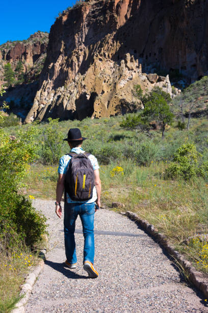 monumento nazionale bandelier, nm: l'uomo anziano cammina oltre le rovine - bandelier national monument foto e immagini stock