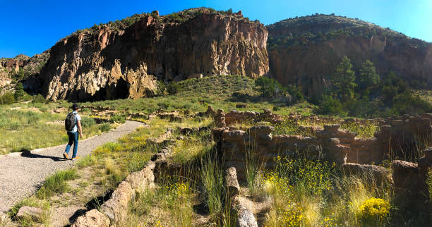 bandelier national monument, nm: senior woman wanderungen vorbei an ruinen - bandelier national monument stock-fotos und bilder