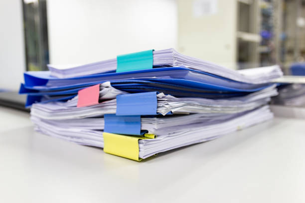 istock file folder and Stack of business report paper file on the table in a work office 1034665354