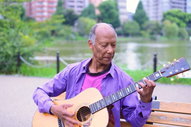 istock Mature individual playing the guitar at a park 1034671060