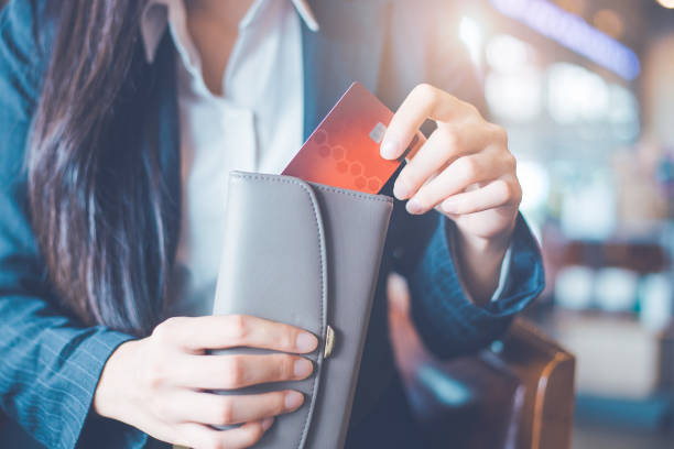 Women's hand Using a credit card, she pulled the card out of her wallet. stock photo