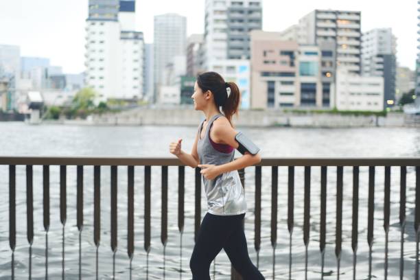 istock Young woman running by the river at dusk 1034680944