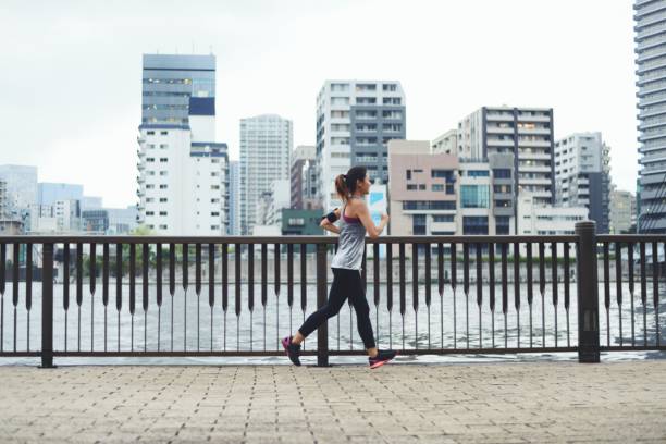 istock Young woman running by the river at dusk 1034680950