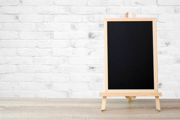 istock Blank vintage wood chalkboard on brick wall background 1034683684