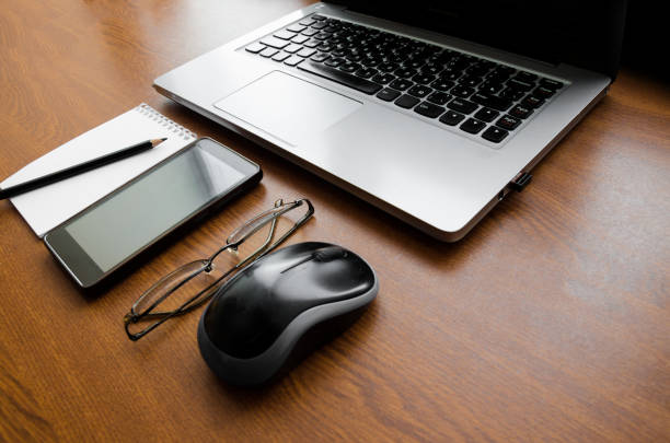 istock Wood office desk table with laptop, glasses, notebook, pen, smartphone. Top view, copy space. 1034700058