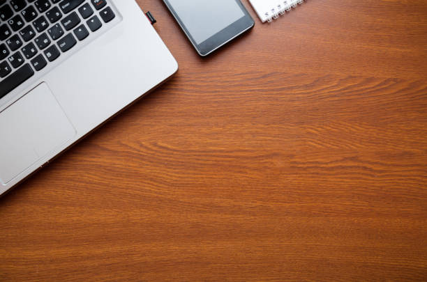 istock Wood office desk table with laptop, glasses, notebook, pen, smartphone. Top view, copy space. 1034700082