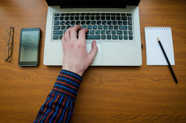 istock Business man using laptop computer hand typing on laptop keyboard with notebook pen glasses 1034702804