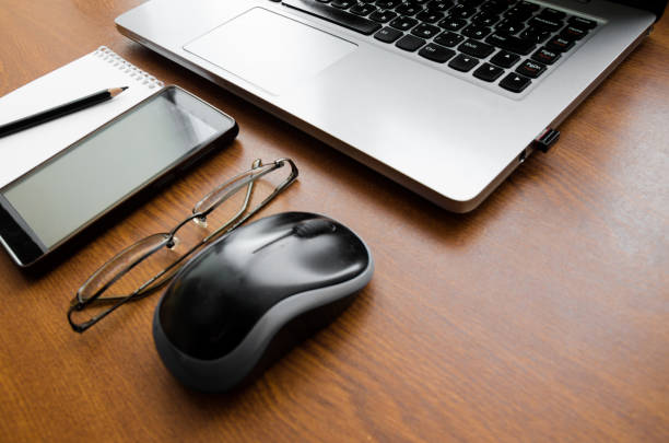istock Wood office desk table with laptop, glasses, notebook, pen, mouse, smartphone. Top view, copy space. 1034702828