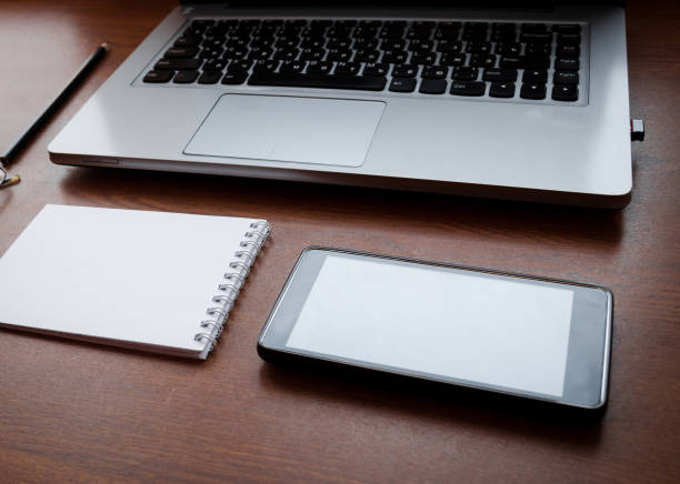 istock Wood office desk table with laptop, glasses, notebook, pen, smartphone. Top view, copy space. 1034702846