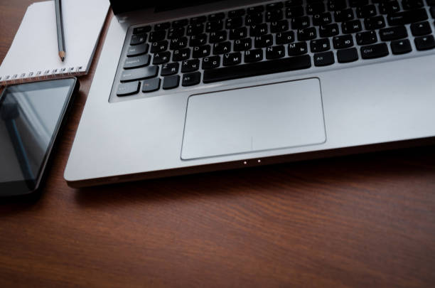 istock Wood office desk table with laptop, glasses, notebook, pen, smartphone. Top view, copy space. 1034702912