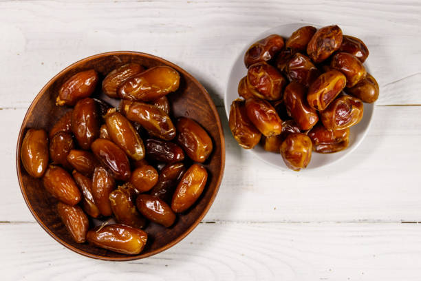 istock Dried dates fruit on white wooden table. Top view 1034705532