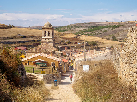Hontanas, Castile and Leon, Spain -  September 14, 2014: Bell tower of the 16th century parish church of the Conception tucked down in a small valley of the Meseta