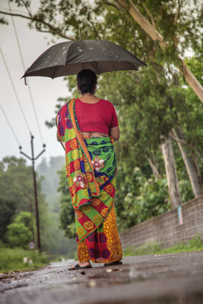 istock Woman standing in the Rain under her Umbrella 1034713080