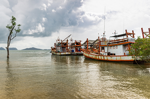 Several Thai fishing boats are moored at the shore of the Andaman Sea at Old Town, Ko Lanta, Krabi, Thailand. The spotlight has recently been on these vessels for allegations of slavery and human trafficking.